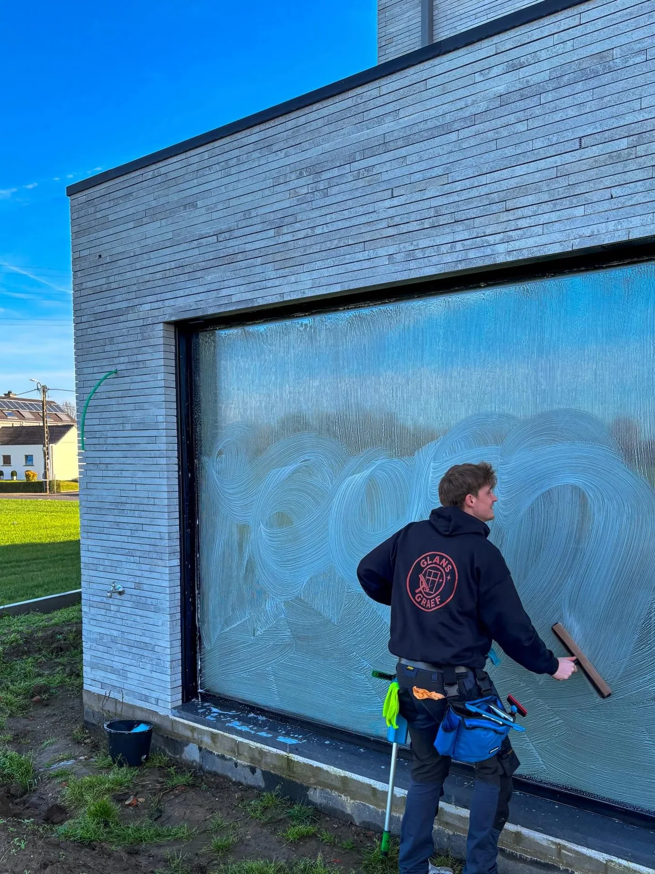 Glans Graef reinigt professioneel een groot raam